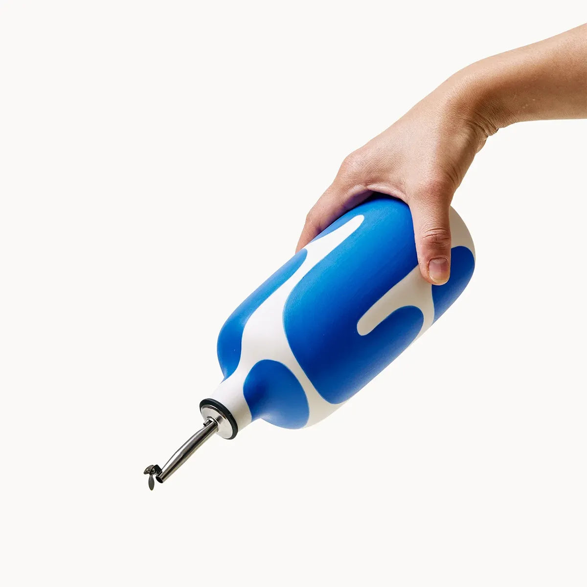 Hand holding a blue and white bottle on a white background