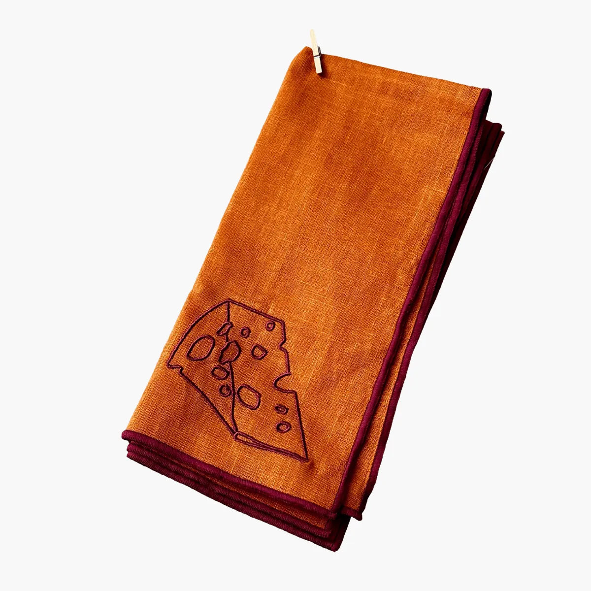 Folded orange napkin with a cheese wedge design on a white background