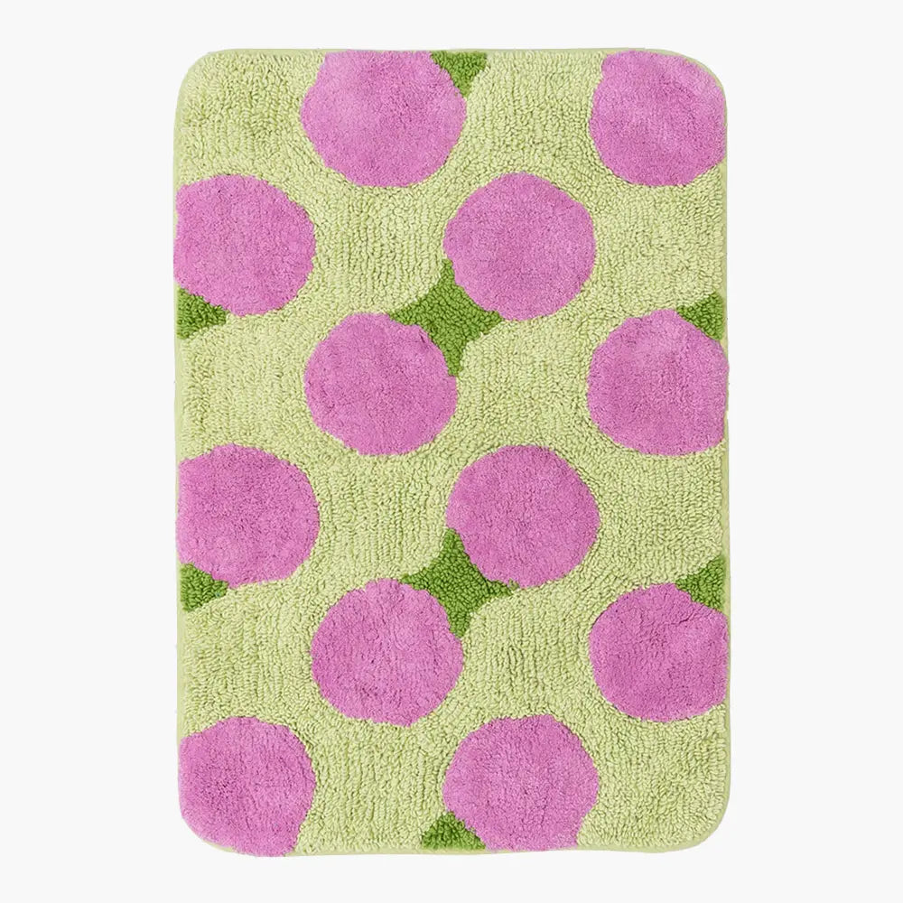 Rectangular bath mat with pink polka dots on a green background
