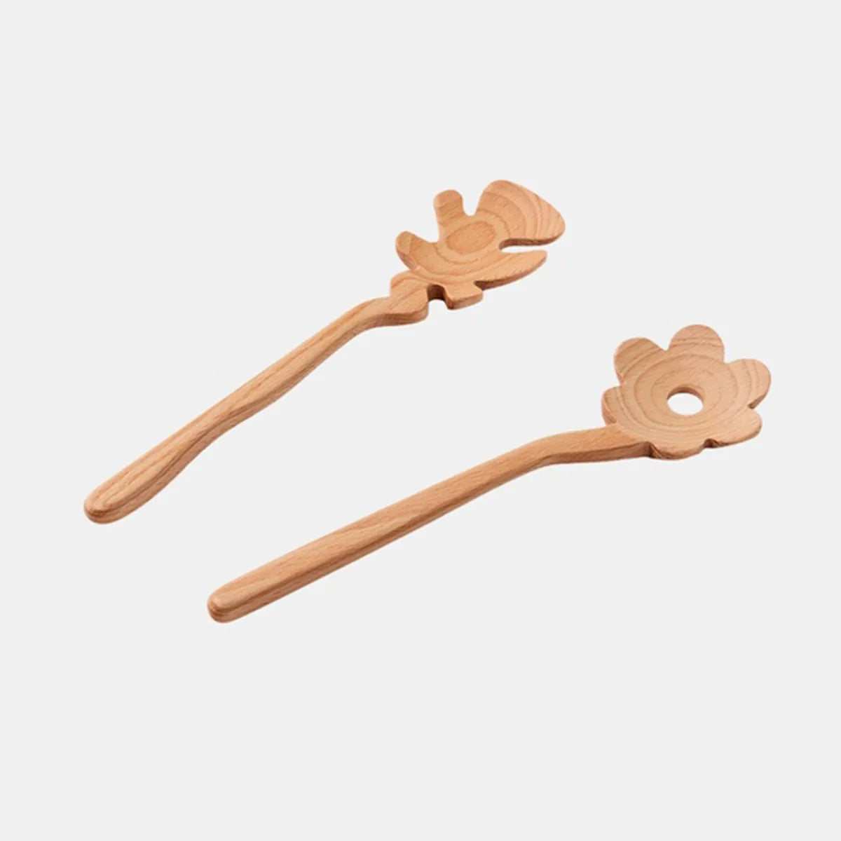 Two light natural wood flower-shaped Serving Friends spoons from Areaware, photographed against a solid light gray background.