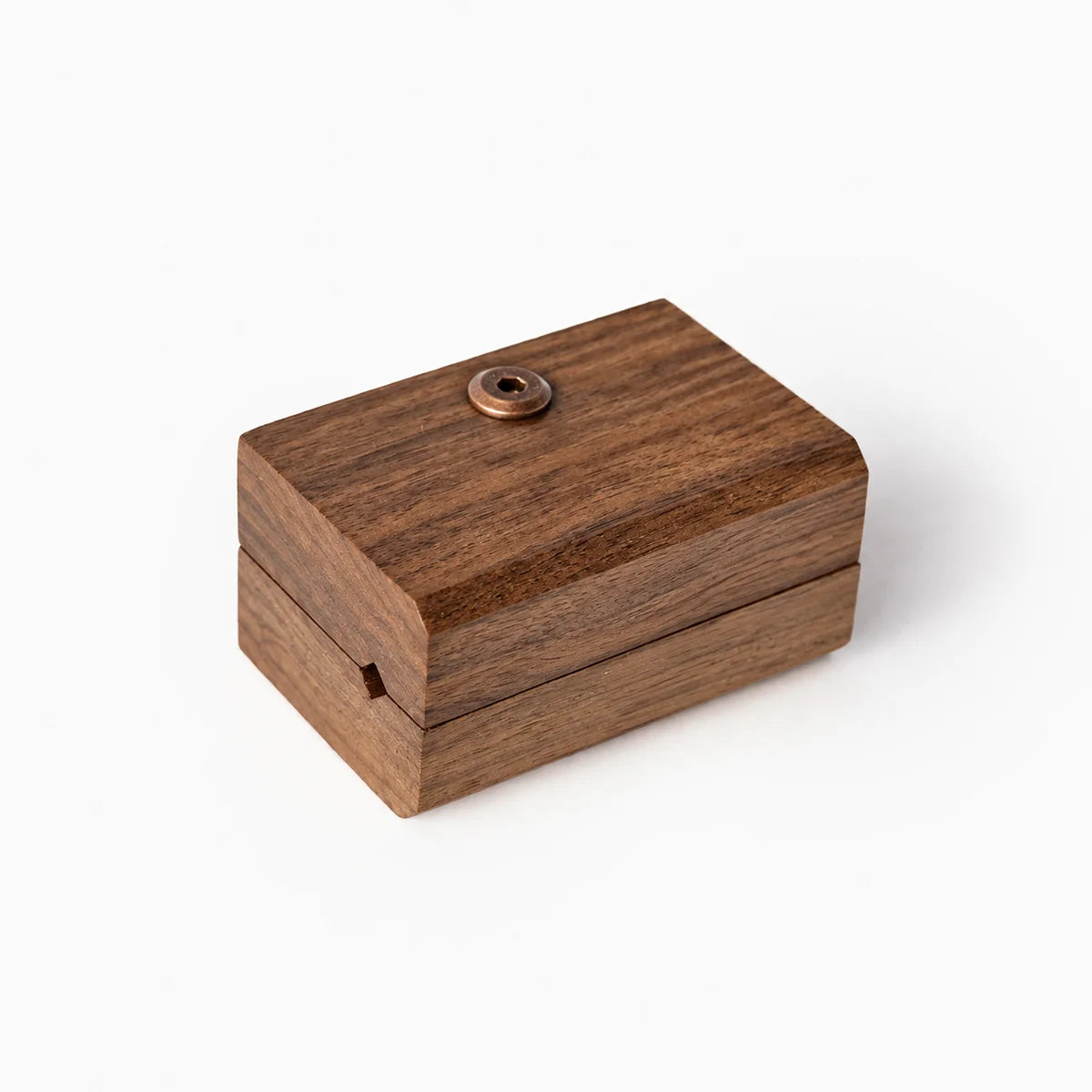 Close up showing one blanket hanger clip in a beautiful walnut grain. A round metal screw on top, set against a plain white background.