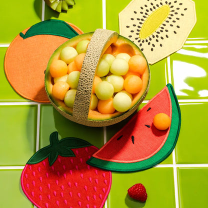 Fruit-themed coasters on a green tiled background