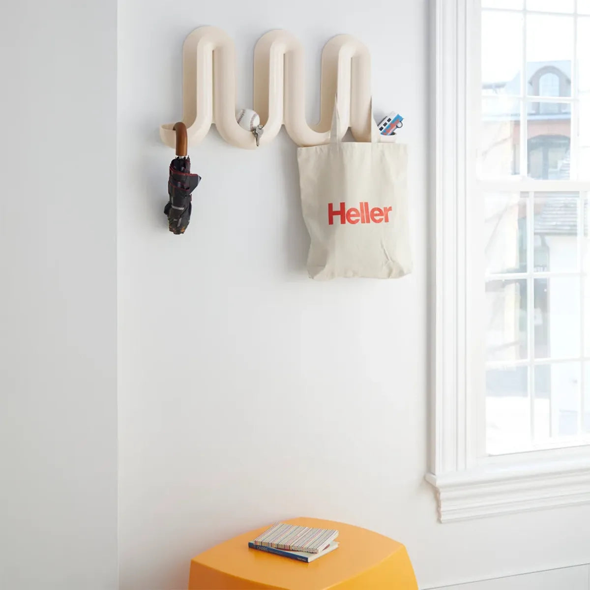A white Heller Swell Wall Catchall and a hanging fabric pouch printed with the red text &