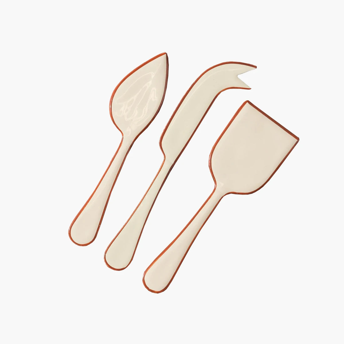 Set of 3 enamel coated stainless steel cheese knives. Cream coloured with a burnt orange outline around the edges. 