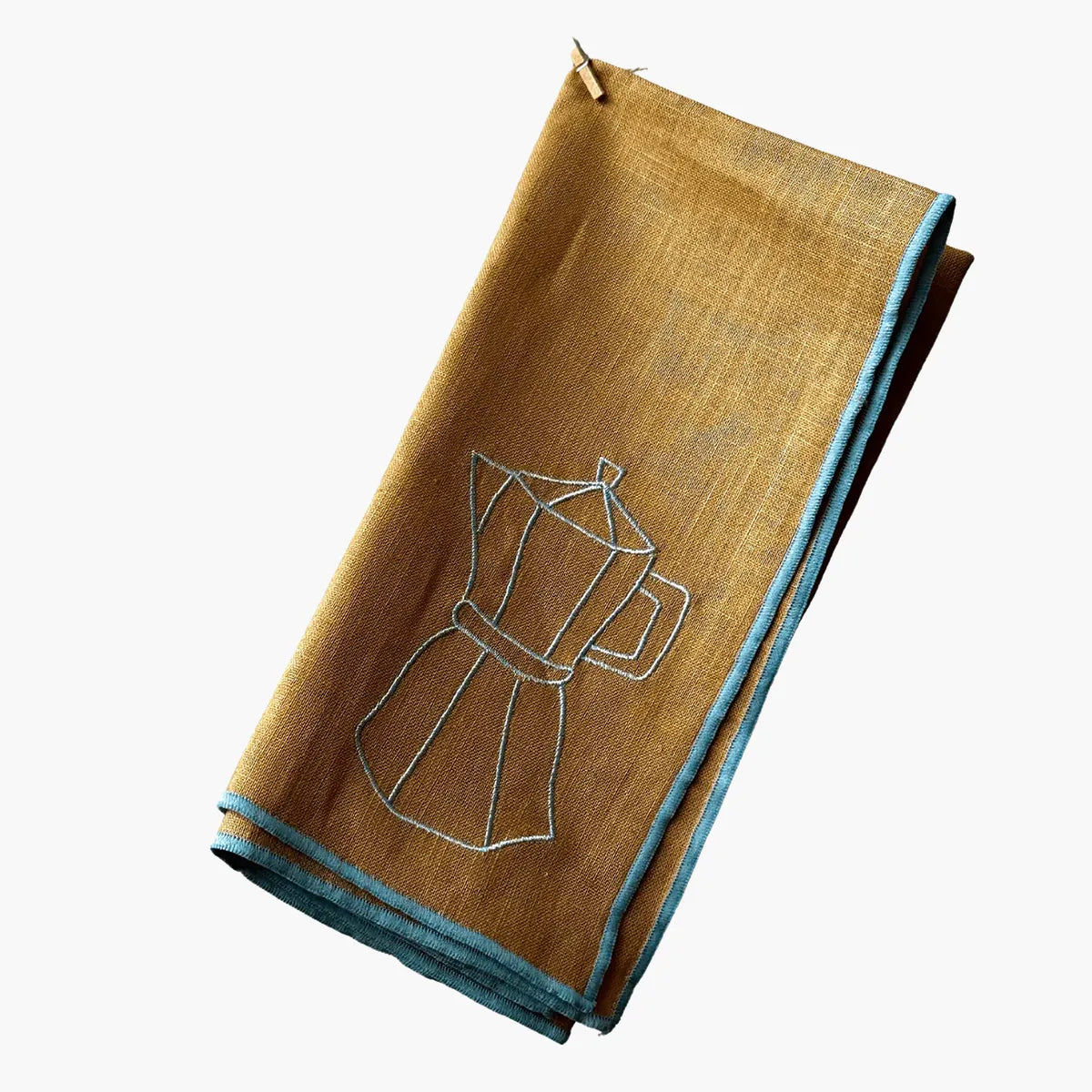 Folded brown napkin with blue embroidery on a white background