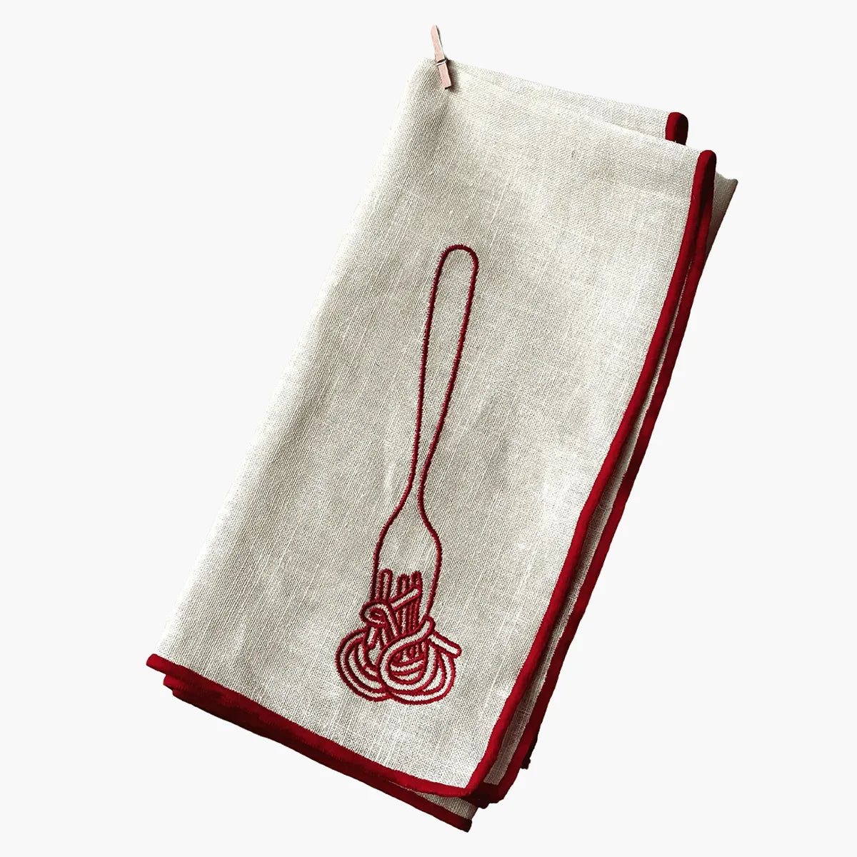 Folded white napkin with red embroidered design on a white background