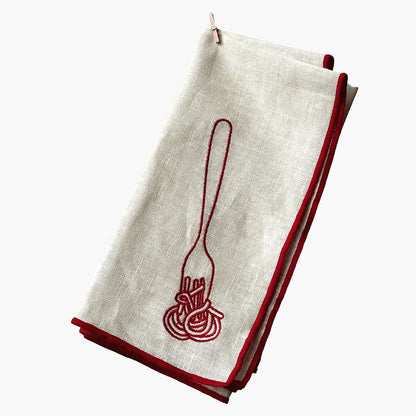 Folded white napkin with red embroidered design on a white background
