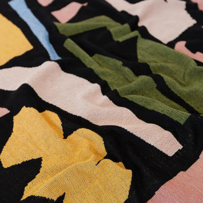 Close-up of a colorful woven blanket fabric with abstract patterns.