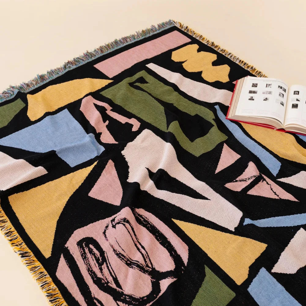 Colorful abstract patterned woven blanket on a beige background