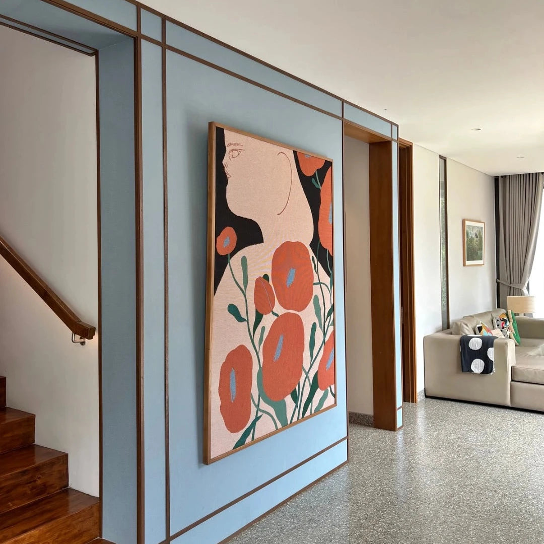 Modern interior with a large abstract tapestrywith red flowers on a light blue wall.